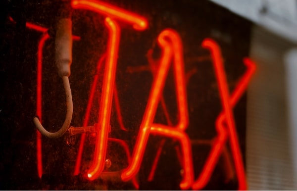The word TAX in red neon lighting